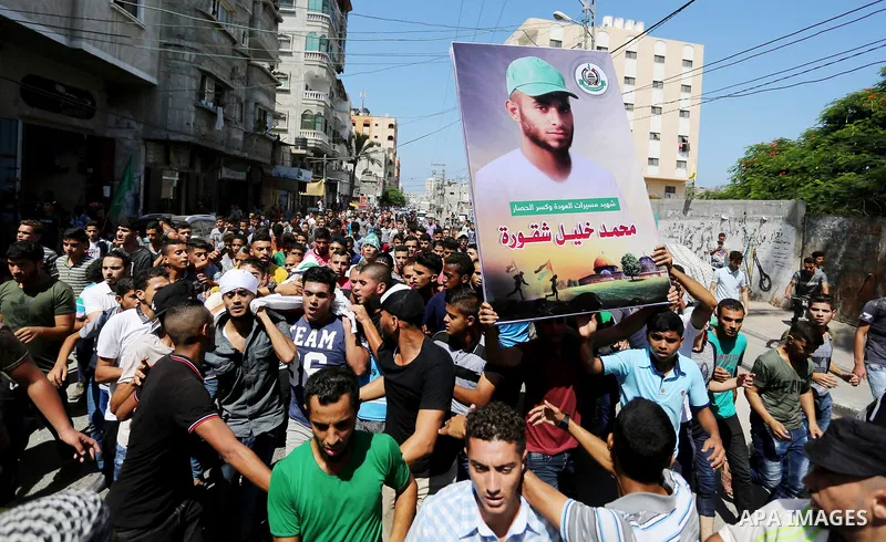 Mourners carry the body of Palestinian Mohammed Shaqoura, 21, who was shot dead by Israeli troops during clashes in tents protest at the Israel-Gaza border, during his funeral in al-Maghazi in the center of Gaza Strip on...
