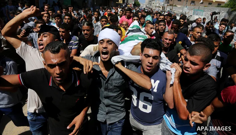 Mourners carry the body of Palestinian Mohammed Shaqoura, 21, who was shot dead by Israeli troops during clashes in tents protest at the Israel-Gaza border, during his funeral in al-Maghazi in the center of Gaza Strip on...