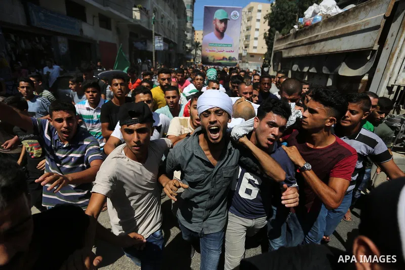 Mourners carry the body of Palestinian Mohammed Shaqoura, 21, who was shot dead by Israeli troops during clashes in tents protest at the Israel-Gaza border, during his funeral in al-Maghazi in the center of Gaza Strip on...