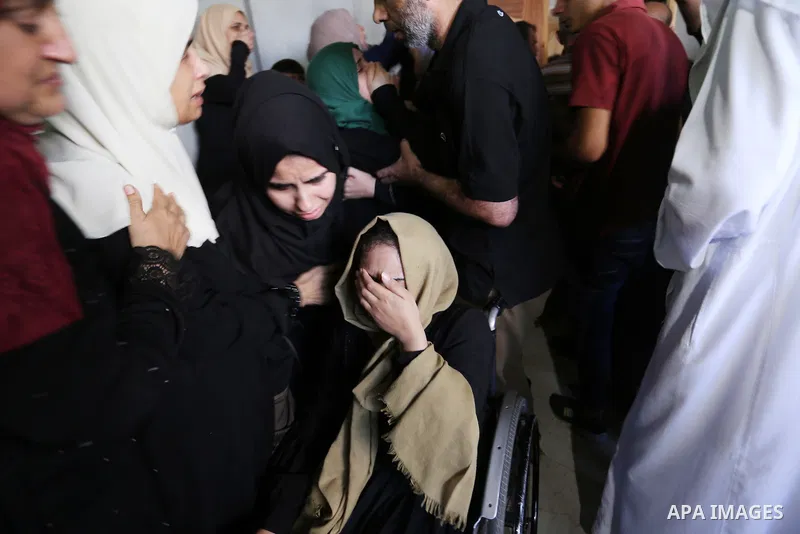 Relatives of Palestinian Mohammed Shaqoura, 21, who was shot dead by Israeli troops during clashes in tents protest at the Israel-Gaza border, mourn during his funeral in al-Maghazi in the center of Gaza Strip on Septemb...