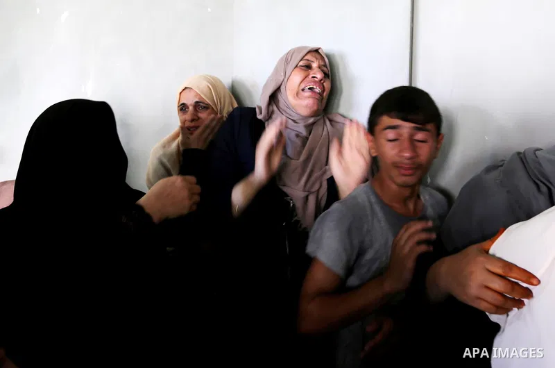 Relatives of Palestinian Mohammed Shaqoura, 21, who was shot dead by Israeli troops during clashes in tents protest at the Israel-Gaza border, mourn during his funeral in al-Maghazi in the center of Gaza Strip on Septemb...
