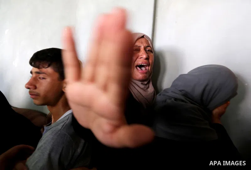 Relatives of Palestinian Mohammed Shaqoura, 21, who was shot dead by Israeli troops during clashes in tents protest at the Israel-Gaza border, mourn during his funeral in al-Maghazi in the center of Gaza Strip on Septemb...