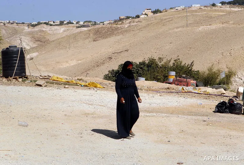 A Palestinian Bedouin woman walks in the village of Khan al-Ahmar in the Israeli occupied West Bank on September 16, 2018. Photo by Wisam Hashlamoun