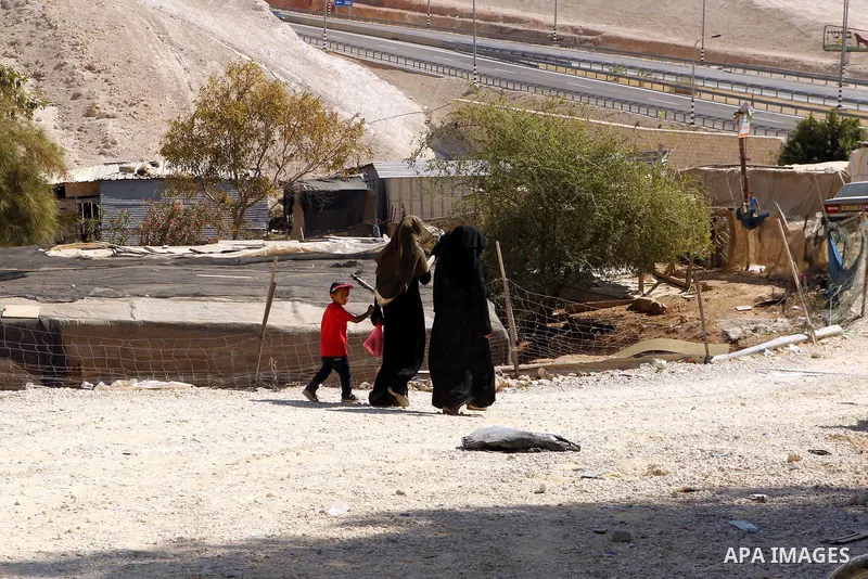 Palestinian Bedouin women walk in the village of Khan al-Ahmar in the Israeli occupied West Bank on September 16, 2018. Photo by Wisam Hashlamoun