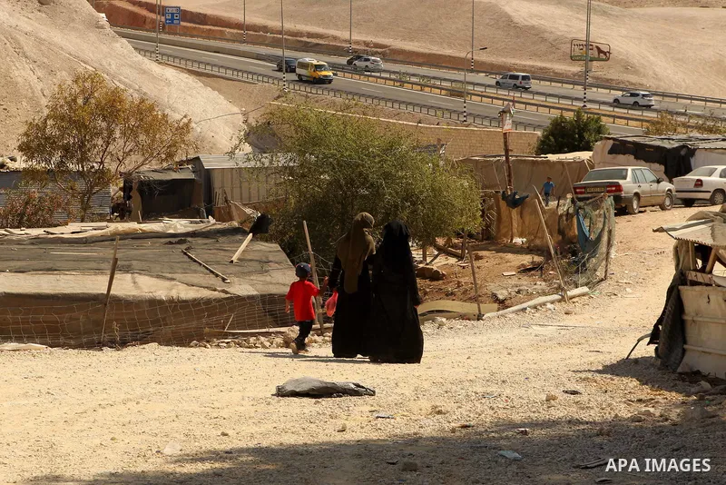 Palestinian Bedouin women walk in the village of Khan al-Ahmar in the Israeli occupied West Bank on September 16, 2018. Photo by Wisam Hashlamoun
