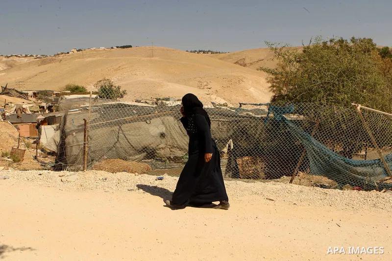 A Palestinian Bedouin woman walks in the village of Khan al-Ahmar in the Israeli occupied West Bank on September 16, 2018. Photo by Wisam Hashlamoun