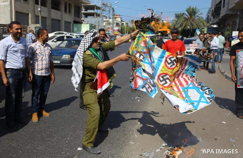 Palestinians burn an Israeli, British and U.S. flags during a protest to show solidarity with Palestinian prisoners held in Israeli jails, in front of Red cross office in Gaza city on September 17, 2018. Photo by Mahmoud...