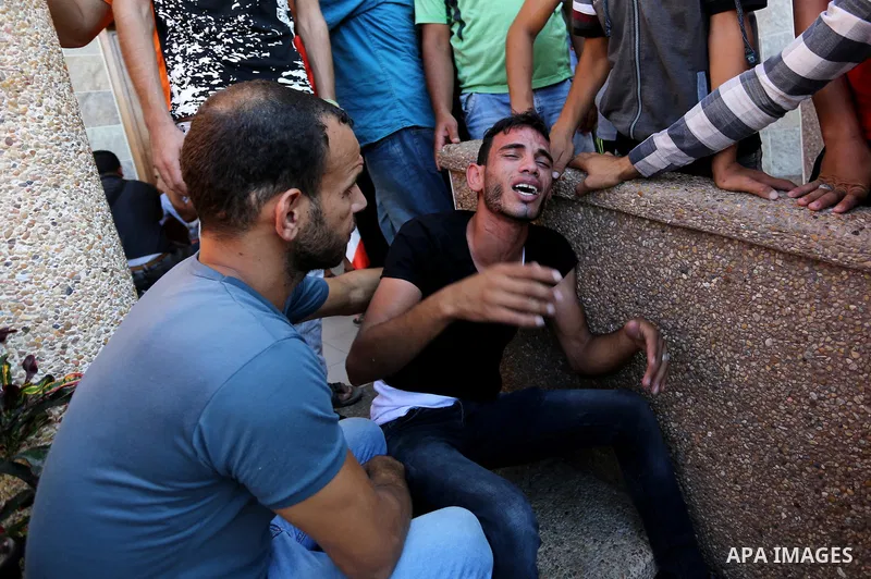 Relatives of two Palestinian men, who were killed in an Israeli air strike at the Israel-Gaza border the night before, mourns outside the hospital, after identifying the bodies in Khan Younis in the southern Gaza Strip o...