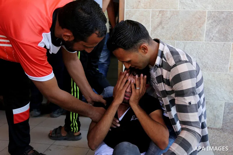 Relatives of two Palestinian men, who were killed in an Israeli air strike at the Israel-Gaza border the night before, mourns outside the hospital, after identifying the bodies in Khan Younis in the southern Gaza Strip o...