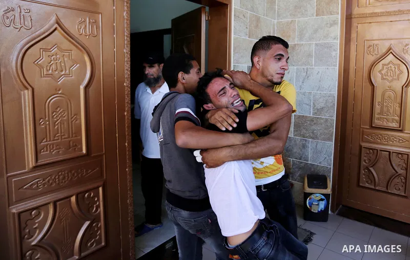 Relatives of two Palestinian men, who were killed in an Israeli air strike at the Israel-Gaza border the night before, mourns outside the hospital, after identifying the bodies in Khan Younis in the southern Gaza Strip o...