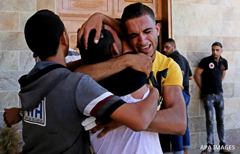 Relatives of two Palestinian men, who were killed in an Israeli air strike at the Israel-Gaza border the night before, mourns outside the hospital, after identifying the bodies in Khan Younis in the southern Gaza Strip o...