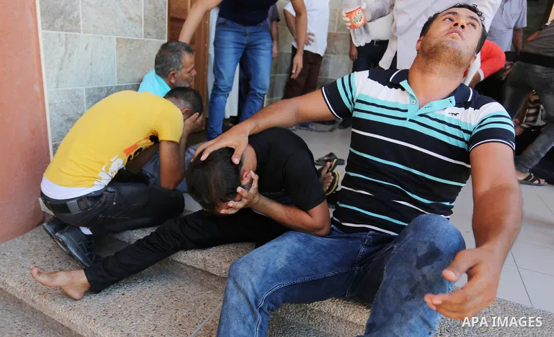 Relatives of two Palestinian men, who were killed in an Israeli air strike at the Israel-Gaza border the night before, mourns outside the hospital, after identifying the bodies in Khan Younis in the southern Gaza Strip o...