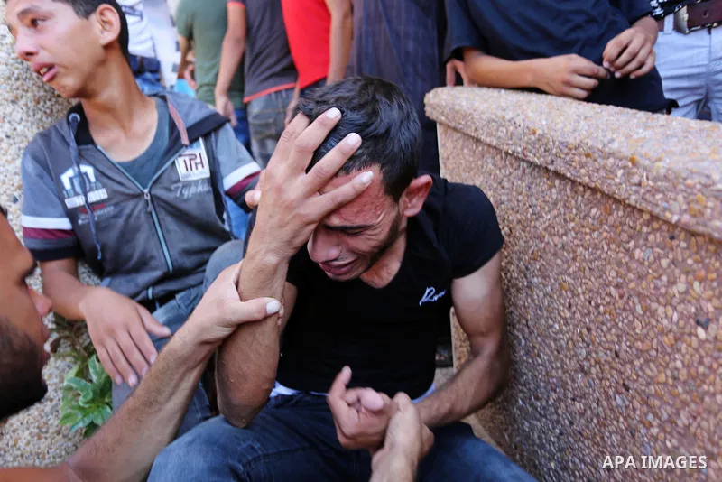 Relatives of two Palestinian men, who were killed in an Israeli air strike at the Israel-Gaza border the night before, mourns outside the hospital, after identifying the bodies in Khan Younis in the southern Gaza Strip o...