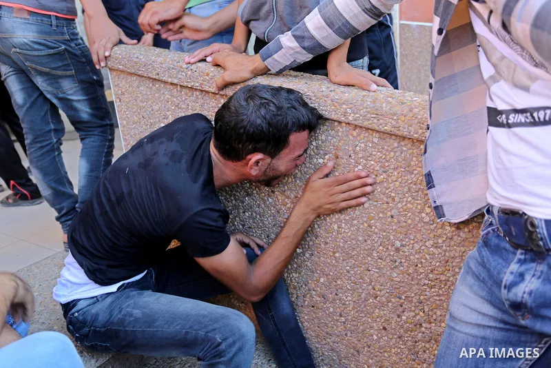 Relatives of two Palestinian men, who were killed in an Israeli air strike at the Israel-Gaza border the night before, mourns outside the hospital, after identifying the bodies in Khan Younis in the southern Gaza Strip o...