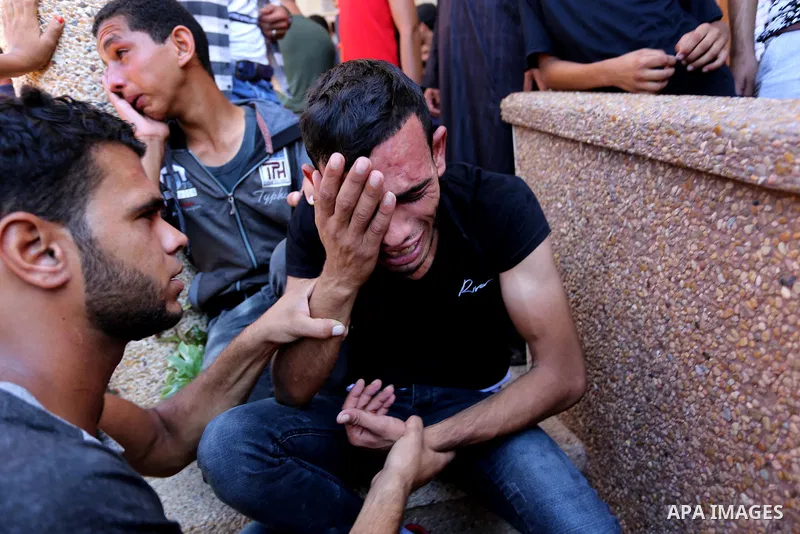 Relatives of two Palestinian men, who were killed in an Israeli air strike at the Israel-Gaza border the night before, mourns outside the hospital, after identifying the bodies in Khan Younis in the southern Gaza Strip o...