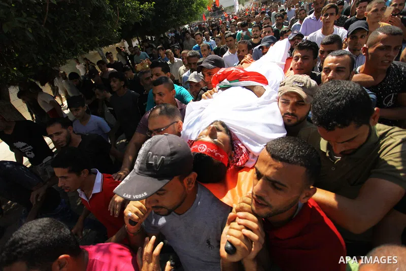 Mourners carry the body of Palestinian Mohamed Abu Nagy who was shot dead by Israeli troops during a demonstration against Israeli blockade on Gaza Strip, at the Erez crossing with Israel during his funeral in Jabalia in...