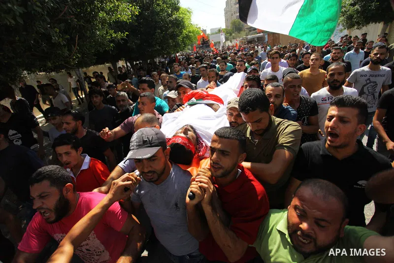 Mourners carry the body of Palestinian Mohamed Abu Nagy who was shot dead by Israeli troops during a demonstration against Israeli blockade on Gaza Strip, at the Erez crossing with Israel during his funeral in Jabalia in...