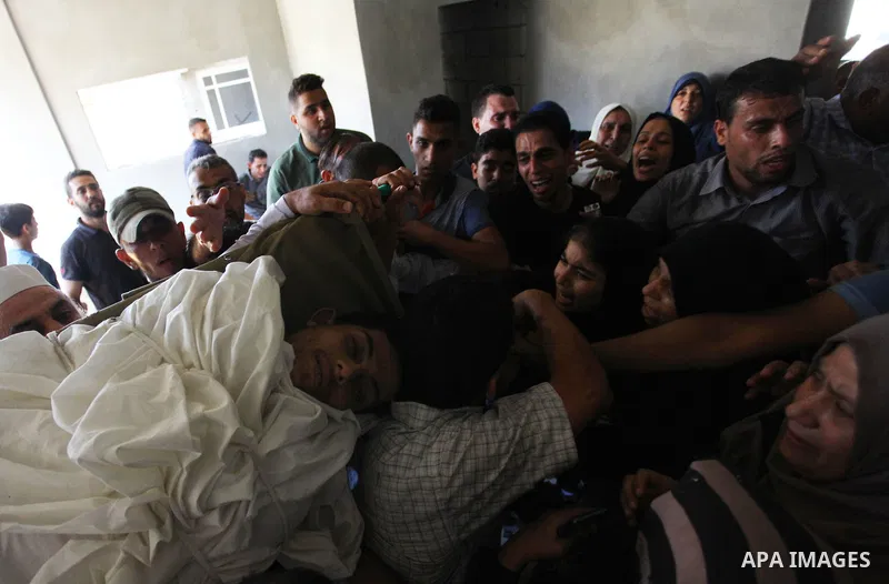 Relatives of Palestinian Ahemd Omar who was shot dead by Israeli troops during a demonstration against Israeli blockade on Gaza Strip, at the Erez crossing with Israel mourn over his body during his funeral at el-Shati r...