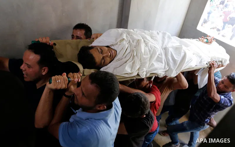 Mourners carry the body of Palestinian Ahemd Omar who was shot dead by Israeli troops during a demonstration against Israeli blockade on Gaza Strip, at the Erez crossing with Israel during his funeral at el-Shati refugee...