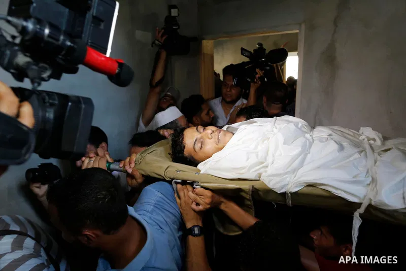 Mourners carry the body of Palestinian Ahemd Omar who was shot dead by Israeli troops during a demonstration against Israeli blockade on Gaza Strip, at the Erez crossing with Israel during his funeral at el-Shati refugee...
