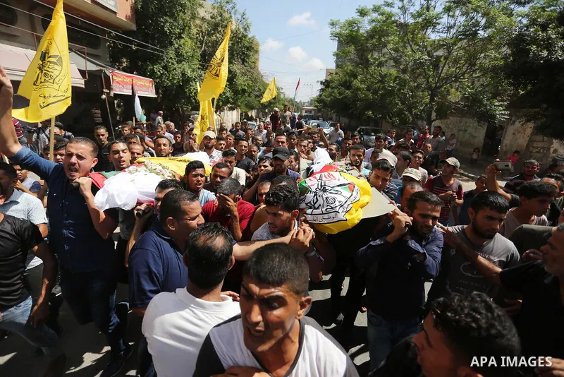 Mourners carry the bodies of Palestinian Alaa Abu Assi and Naji Abu Assi who were killed in an Israeli air strike at the Israel-Gaza border during their funeral in Khan Younis in the southern Gaza Strip on September 19,...
