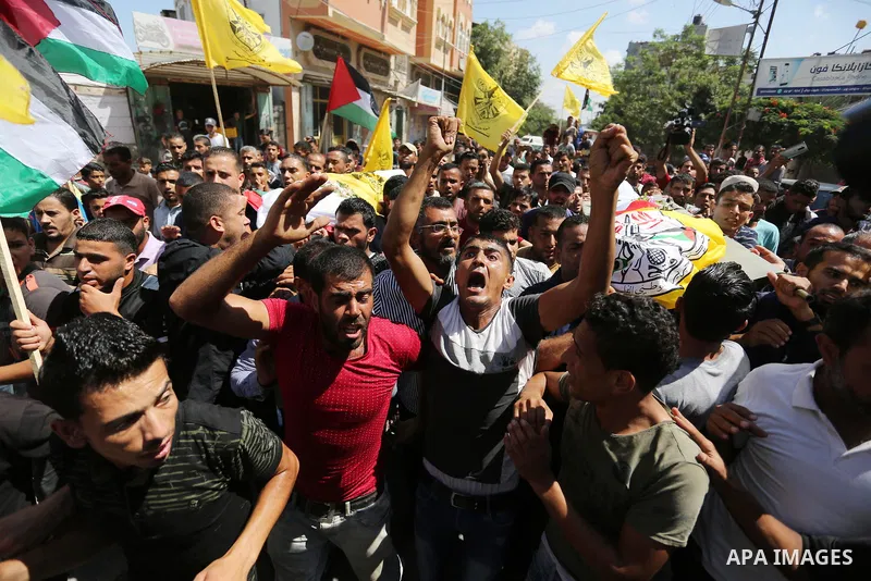 Mourners carry the bodies of Palestinian Alaa Abu Assi and Naji Abu Assi who were killed in an Israeli air strike at the Israel-Gaza border during their funeral in Khan Younis in the southern Gaza Strip on September 19,...