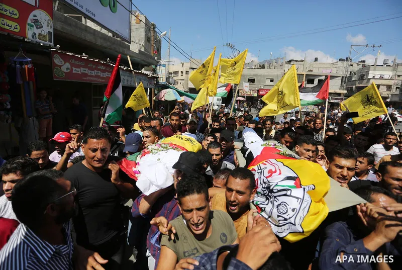 Mourners carry the bodies of Palestinian Alaa Abu Assi and Naji Abu Assi who were killed in an Israeli air strike at the Israel-Gaza border during their funeral in Khan Younis in the southern Gaza Strip on September 19,...