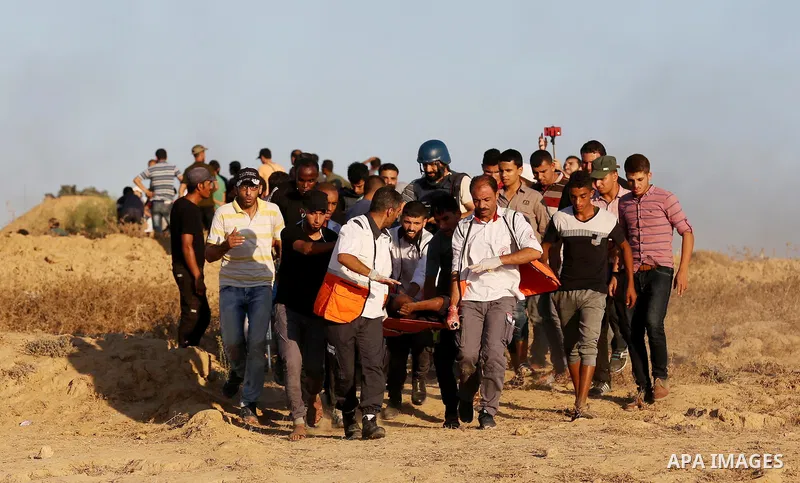 A wounded Palestinian protester is evacuated during clashes with Israeli forces in tents protest where Palestinians demand the right to return to their homeland at the Israel-Gaza border, in Deir al-Balah in the center o...