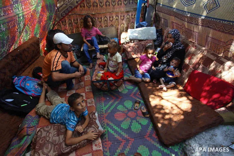 Palestinian Waleed Abu Shawish and his family sit inside their tent as he can't pay rent of house, in the middle of Gaza City, on September 20, 2018. Photo by Mahmoud Ajour