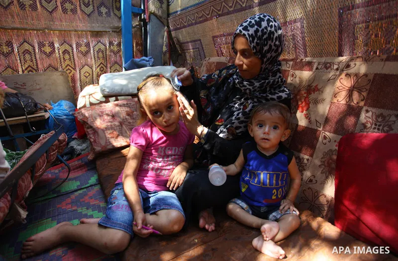 Palestinian Waleed Abu Shawish and his family sit inside their tent as he can't pay rent of house, in the middle of Gaza City, on September 20, 2018. Photo by Mahmoud Ajour