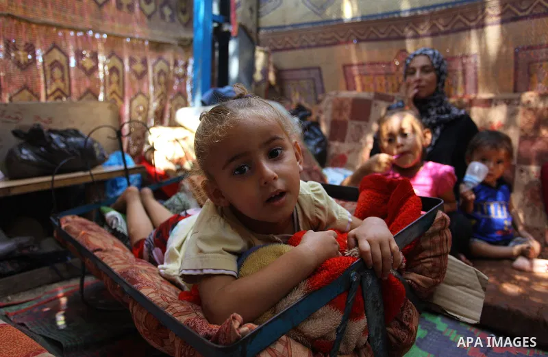 Palestinian Waleed Abu Shawish and his family sit inside their tent as he can't pay rent of house, in the middle of Gaza City, on September 20, 2018. Photo by Mahmoud Ajour
