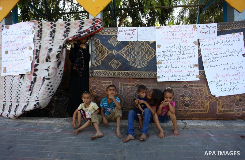 Palestinian Waleed Abu Shawish and his family sit outside their tent as he can't pay rent of house, in the middle of Gaza City, on September 20, 2018. Photo by Mahmoud Ajour