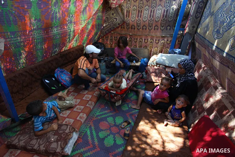 Palestinian Waleed Abu Shawish and his family sit inside their tent as he can't pay rent of house, in the middle of Gaza City, on September 20, 2018. Photo by Mahmoud Ajour