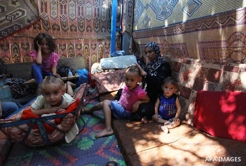 Palestinian Waleed Abu Shawish and his family sit inside their tent as he can't pay rent of house, in the middle of Gaza City, on September 20, 2018. Photo by Mahmoud Ajour