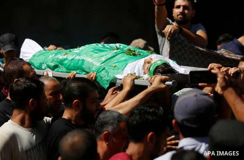 Mourners carry the body of Palestinian Mo'men Abu Eyada 15, who was shot dead by Israeli troops during clashes in tents protest at the Israel-Gaza border, during his funeral in Rafah in the southern Gaza Strip on Septemb...