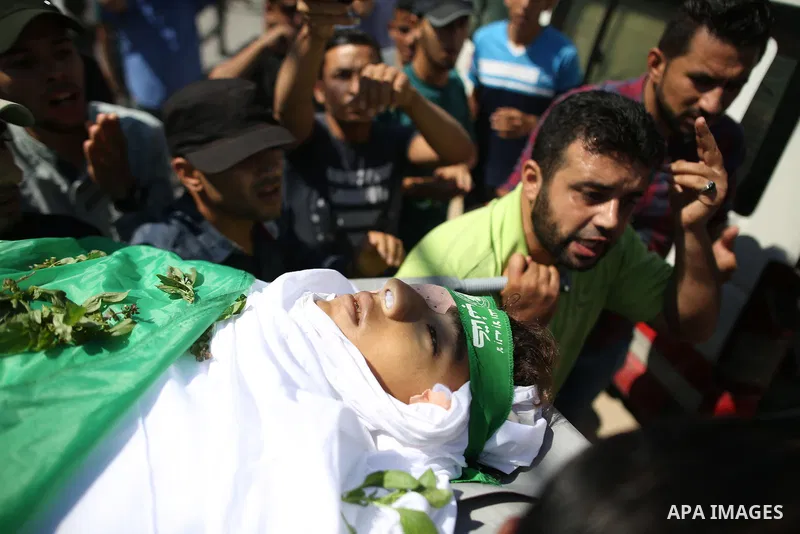 Mourners carry the body of Palestinian Mo'men Abu Eyada 15, who was shot dead by Israeli troops during clashes in tents protest at the Israel-Gaza border, during his funeral in Rafah in the southern Gaza Strip on Septemb...