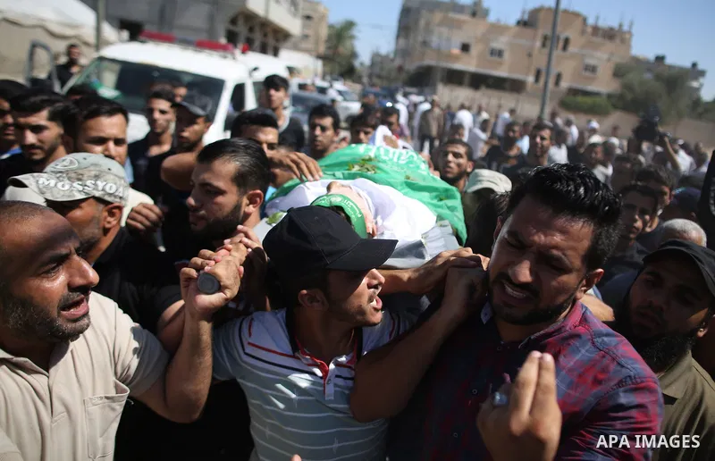 Mourners carry the body of Palestinian Mo'men Abu Eyada 15, who was shot dead by Israeli troops during clashes in tents protest at the Israel-Gaza border, during his funeral in Rafah in the southern Gaza Strip on Septemb...