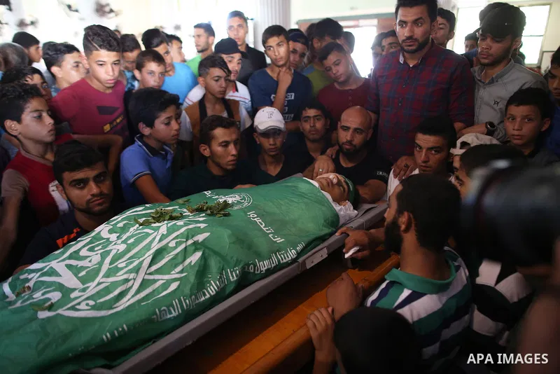 Mourners carry the body of Palestinian Mo'men Abu Eyada 15, who was shot dead by Israeli troops during clashes in tents protest at the Israel-Gaza border, during his funeral in Rafah in the southern Gaza Strip on Septemb...