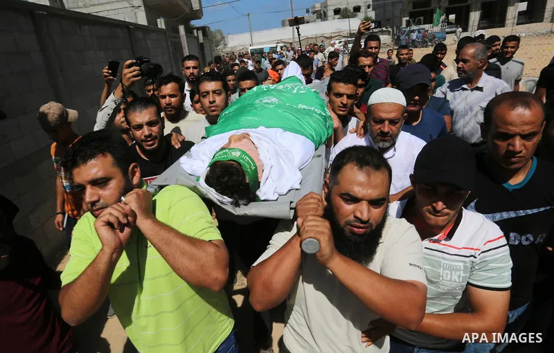 Mourners carry the body of Palestinian Mo'men Abu Eyada 15, who was shot dead by Israeli troops during clashes in tents protest at the Israel-Gaza border, during his funeral in Rafah in the southern Gaza Strip on Septemb...
