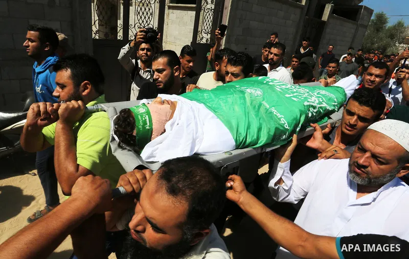 Mourners carry the body of Palestinian Mo'men Abu Eyada 15, who was shot dead by Israeli troops during clashes in tents protest at the Israel-Gaza border, during his funeral in Rafah in the southern Gaza Strip on Septemb...