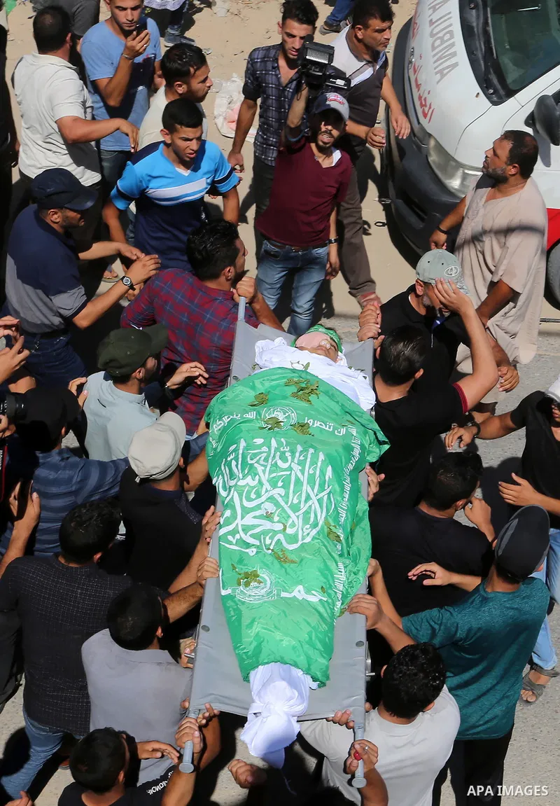Mourners carry the body of Palestinian Mo'men Abu Eyada 15, who was shot dead by Israeli troops during clashes in tents protest at the Israel-Gaza border, during his funeral in Rafah in the southern Gaza Strip on Septemb...