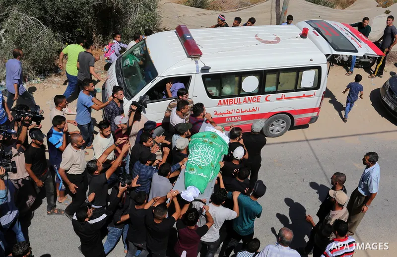 Mourners carry the body of Palestinian Mo'men Abu Eyada 15, who was shot dead by Israeli troops during clashes in tents protest at the Israel-Gaza border, during his funeral in Rafah in the southern Gaza Strip on Septemb...