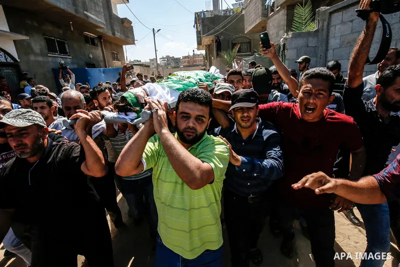 Mourners carry the body of Palestinian Mo'men Abu Eyada 15, who was shot dead by Israeli troops during clashes in tents protest at the Israel-Gaza border, during his funeral in Rafah in the southern Gaza Strip on Septemb...
