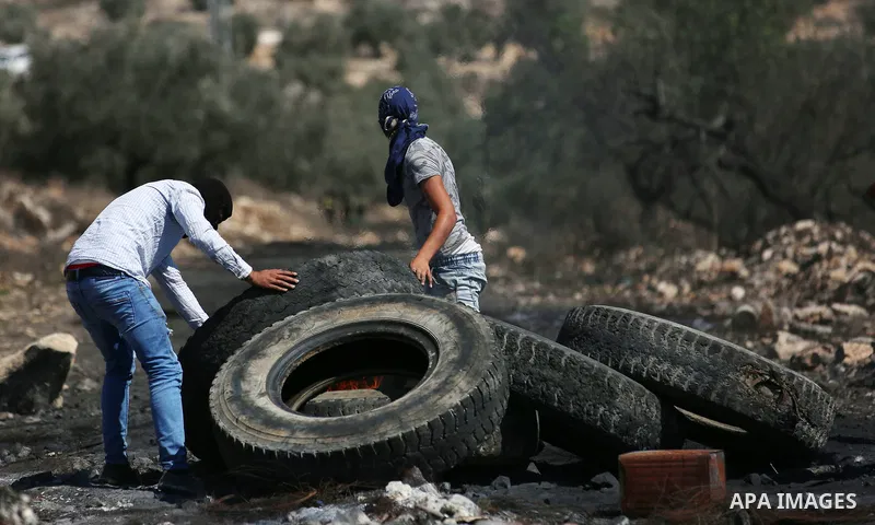 Palestinian protesters burn tires during clashes with Israeli forces following a weekly demonstration against the expropriation of Palestinian land by Israel in the village of Kfar Qaddum, near the West Bank city of Nabl...