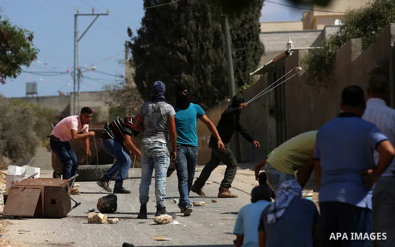 Palestinian protesters hurl stones towards Israeli forces during clashes following a weekly demonstration against the expropriation of Palestinian land by Israel in the village of Kfar Qaddum, near the West Bank city of...