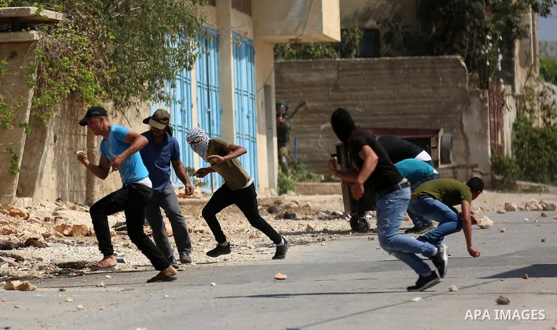 Palestinian protesters hurl stones towards Israeli forces during clashes following a weekly demonstration against the expropriation of Palestinian land by Israel in the village of Kfar Qaddum, near the West Bank city of...