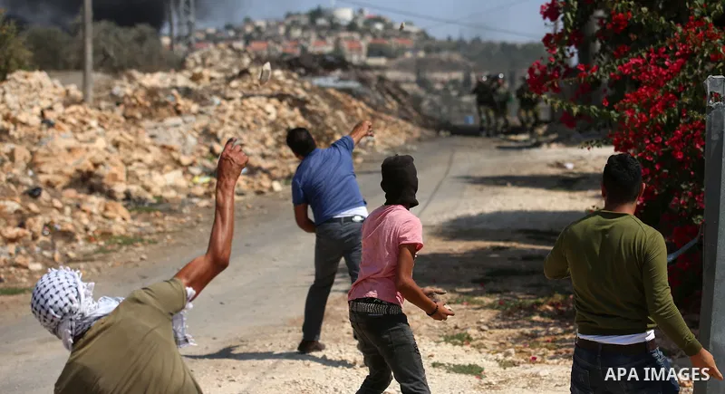 Palestinian protesters hurl stones towards Israeli forces during clashes following a weekly demonstration against the expropriation of Palestinian land by Israel in the village of Kfar Qaddum, near the West Bank city of...