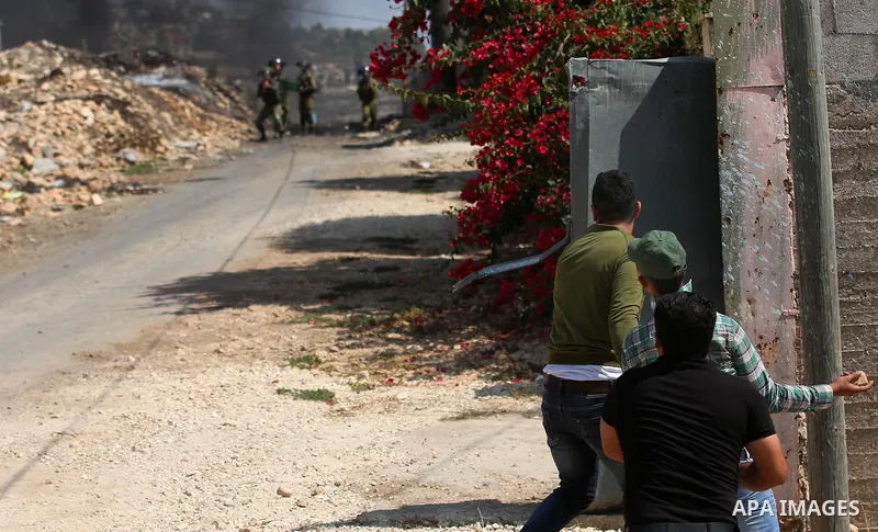 Palestinian protesters hurl stones towards Israeli forces during clashes following a weekly demonstration against the expropriation of Palestinian land by Israel in the village of Kfar Qaddum, near the West Bank city of...