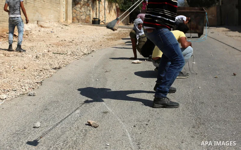 Palestinian protesters hurl stones towards Israeli forces during clashes following a weekly demonstration against the expropriation of Palestinian land by Israel in the village of Kfar Qaddum, near the West Bank city of...