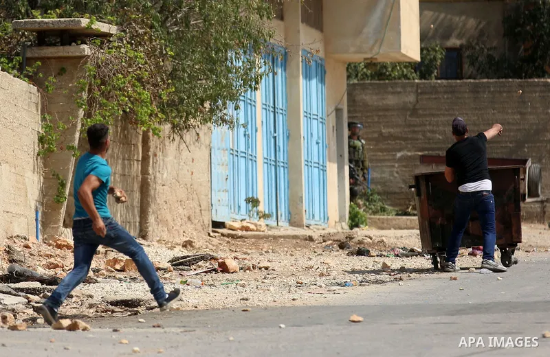 Palestinian protesters hurl stones towards Israeli forces during clashes following a weekly demonstration against the expropriation of Palestinian land by Israel in the village of Kfar Qaddum, near the West Bank city of...